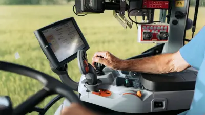 Old man sitting in a tractor and operating it