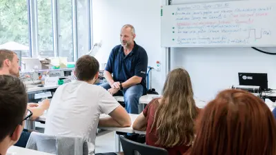 Team member conducting a collaborative workshop with a group of students in a classroom setting.