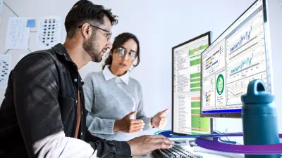 Two developers sitting in front of a computer using ETAS software