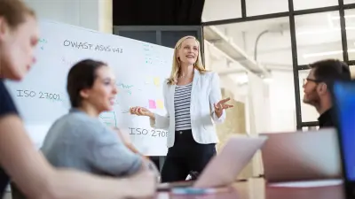 Team discusses and woman stands at the flipchart