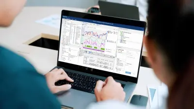 Two people operate the application on the laptop