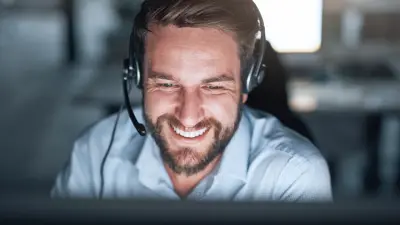 Smiling customer support representative wearing a headset, engaged in an online conversation, symbolizing professional and friendly technical assistance.