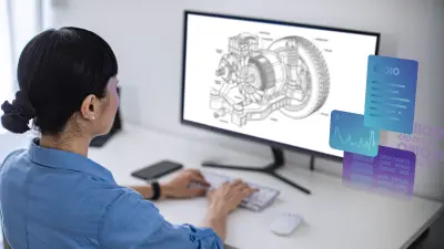 Engineer working at a computer displaying a mechanical CAD drawing with overlaid data visualization panels.