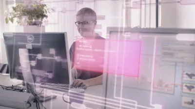 이 이미지는 한 남성이 PC 앞에 앉아 ECU 소프트웨어 애플리케이션을 코딩하는 모습을 보여줍니다. 사진에는 EHANDBOOK 소프트웨어의 이미지가 오버레이되어 있습니다.